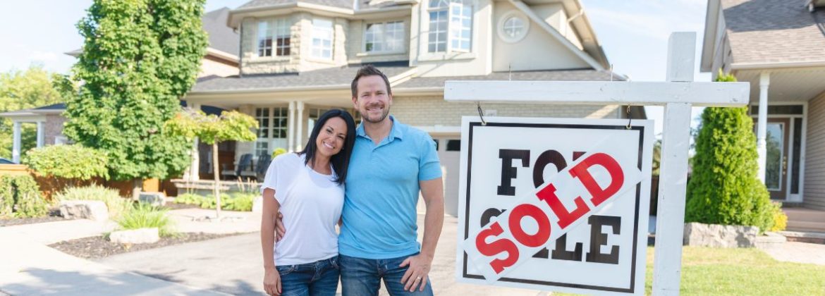 Couple standing in front of new home