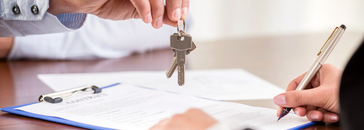 Women handing over the house keys to ne owner after Real Estate Closings