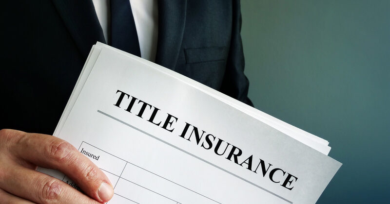 Title Insurance agreement in the hands of a businessman.